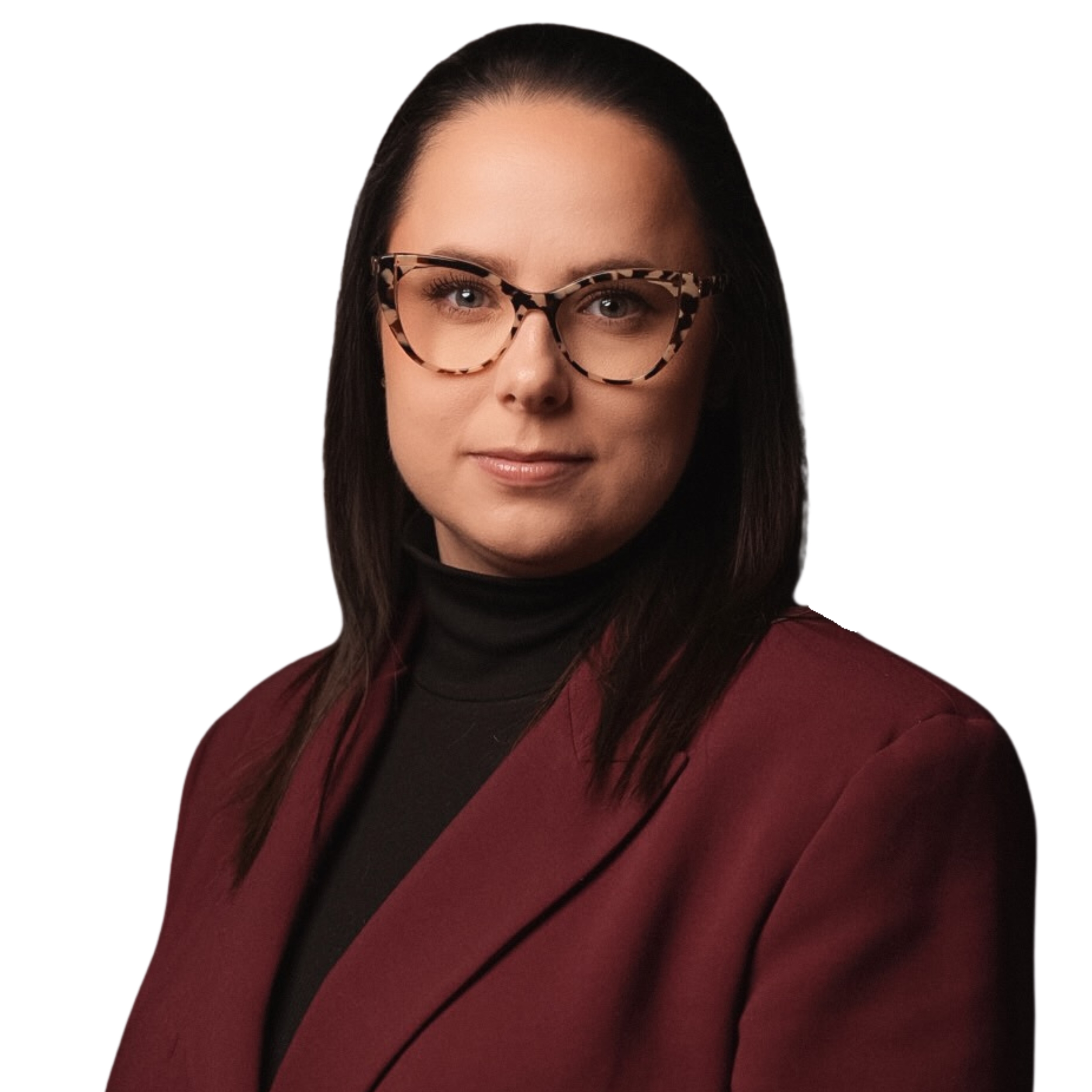 Zdjęcie przedstawia portret ciemnowłosej kobiety w okularach, ubrana w ciemny golf i bordową marynarkę