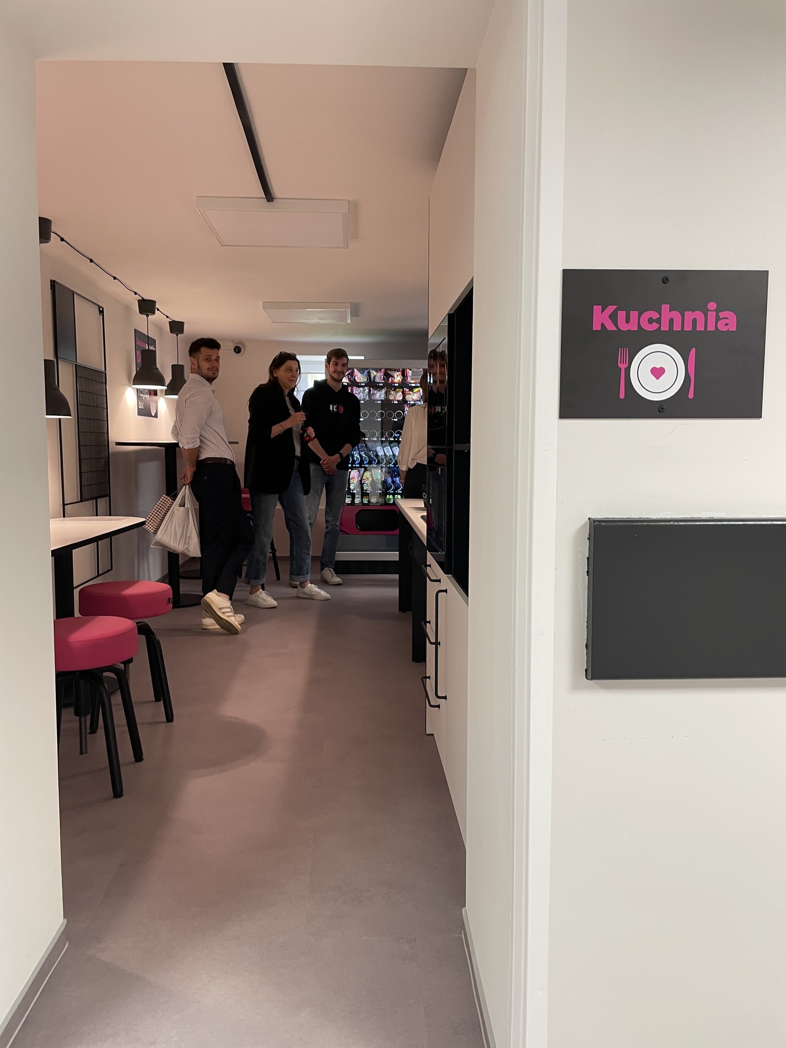 Rozmawiająca grupa studentów i wykładowców w kuchni